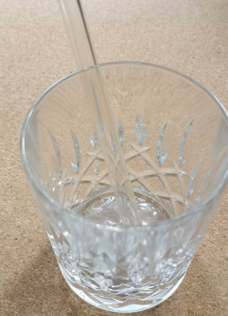 Glas-Strohalm-Test: ein transparentes Modell in einem Kristallglas von oben betrachtet.