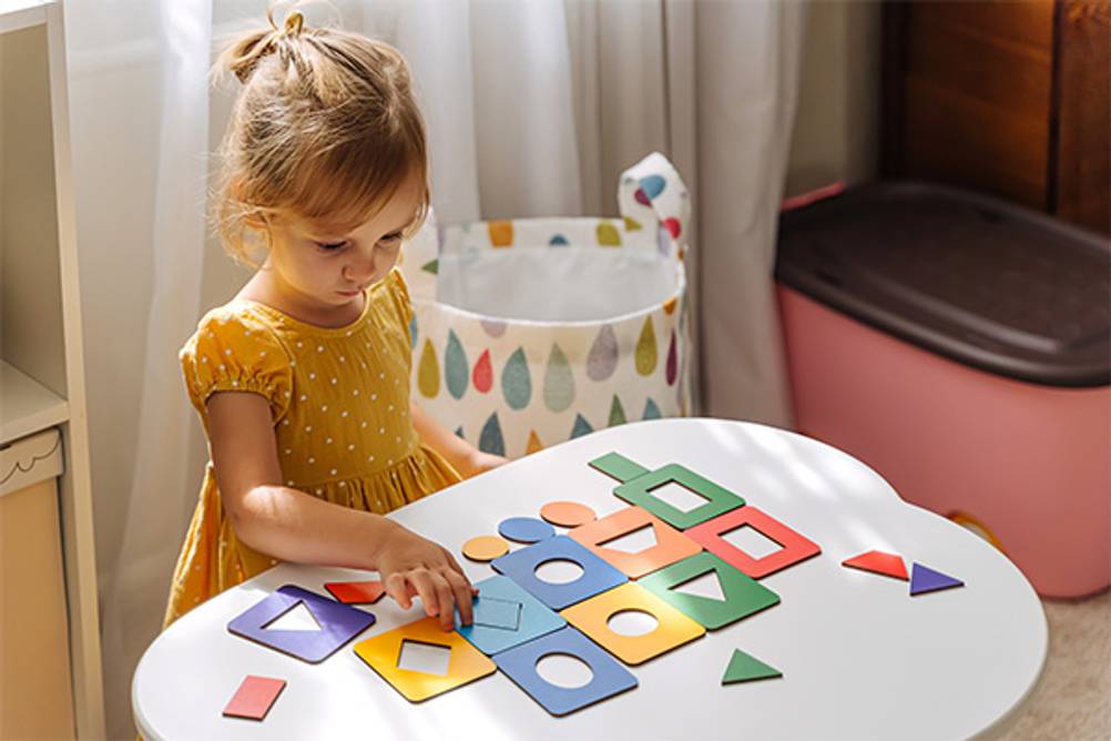 Lernspielzeug ab 2 Jahre im Test: Ein kleines Mädchen welches ein Holzpuzzle macht.
