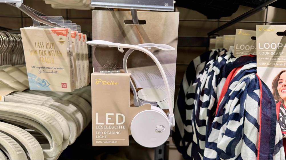In einem Regal häng die getestete Leselampe neben anderen Produkten.