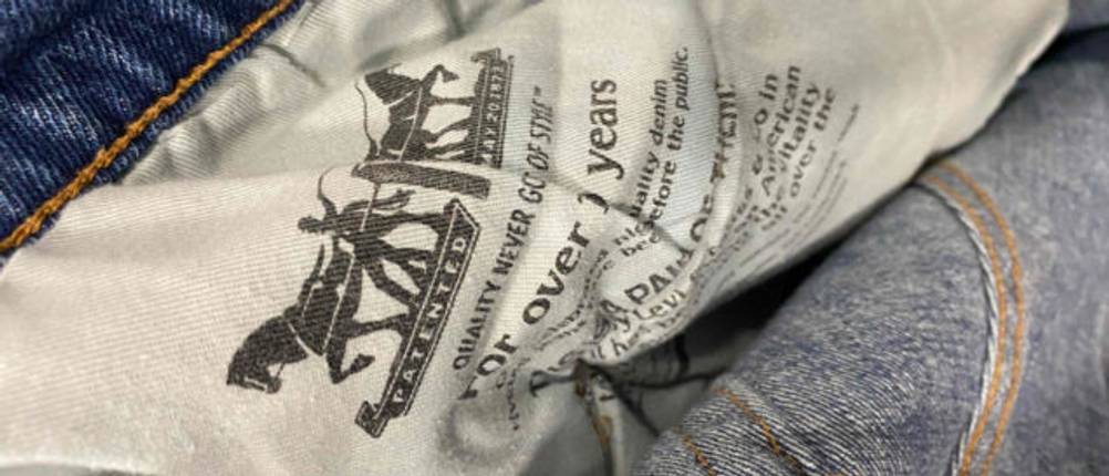 Innenansicht einer Levis-Jeans für Herren im Test: Detail der weißen Innenvordertasche inklusive Produktinformationen einer blauen Jeans.