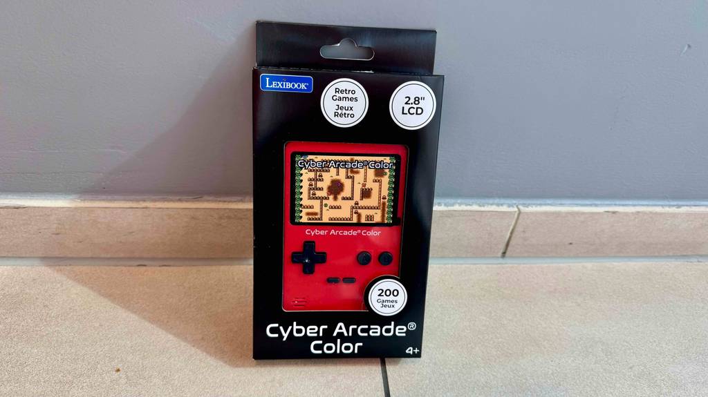 Getestet: Ein Retro-Spielekonsole in Rot befindet sich innerhalb der Verpackung vor einer grauen Wand.
