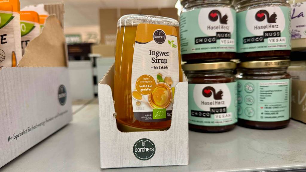 Ingwersirup im Test: Mehrere Quetschtuben stehen zwischen anderen Produkten in einem Regal.