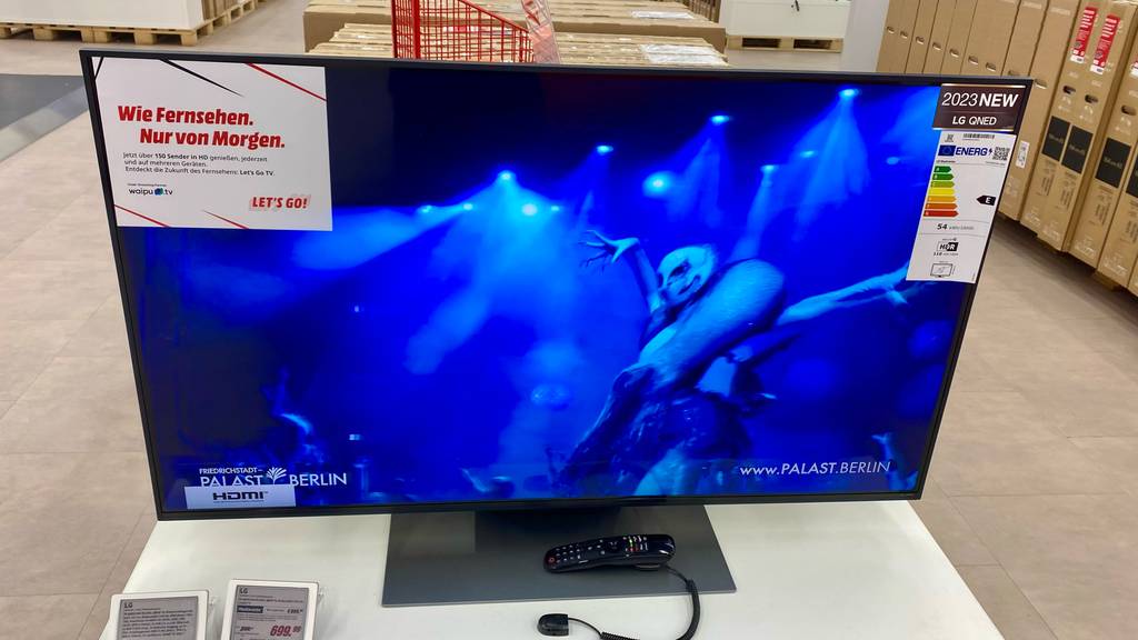 Eingeschalteter 50-Zoll-Fernseher mit Fernbedienung im Laden.