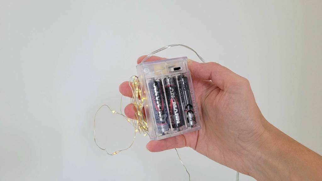 Lichterkette-Test: eine batteriebetriebene Lichterkette, die in einer Hand gehalten wird.