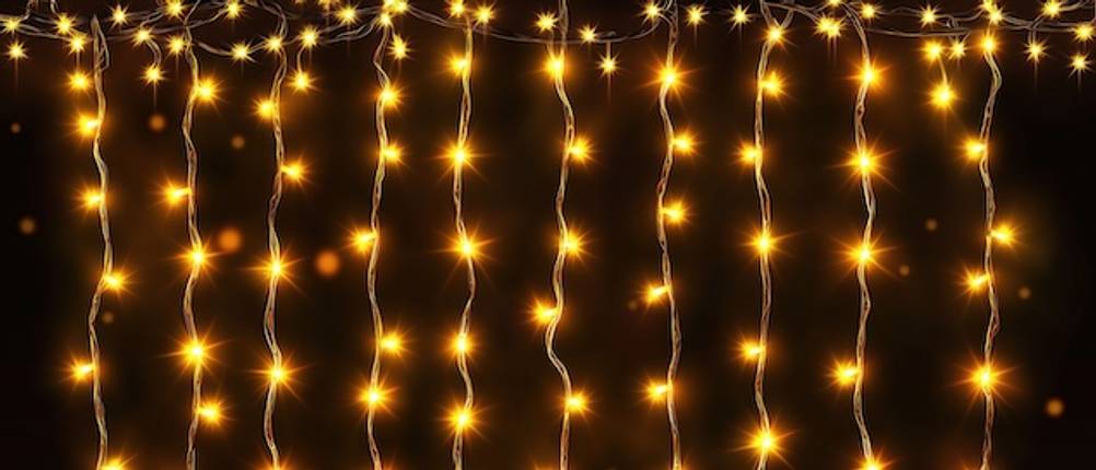 Lichtervorhang im Test: Gelbe LED-Lichter eines Lichtervorhangs vor einem schwarzen Hintergrund.