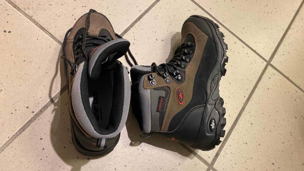 Unisex Bergschuhe im Test: Ein Schuhe liegt seitlich neben einem stehenden, in Ansicht von oben.