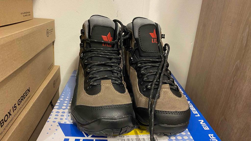 Frontansicht eines getesteten Paars Unisex Bergschuhe, das auf einem Schuhkarton steht.