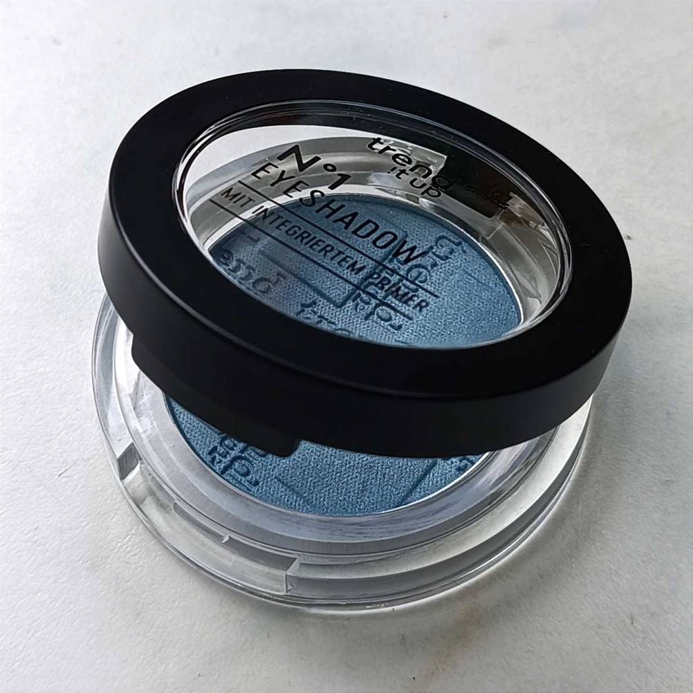 Im Test: Ein Lidschatten mit leicht geöffnetem Deckel auf einer hellen Fläche.