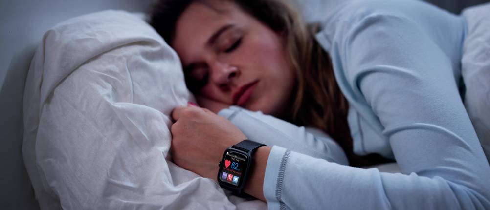 LIGE-Smartwatch-Test: Frau mit einer Smartwatch, die in ihrem Bett schläft