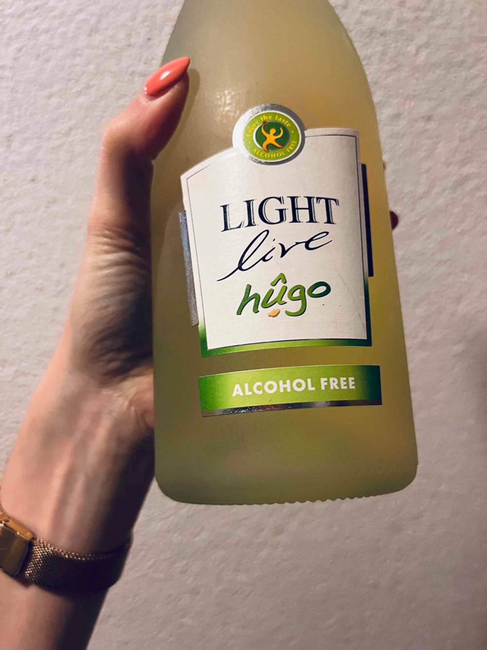 Nahaufnahme auf das Label einer Flasche getesteten alkoholfreien Sektes die eine Hand hält.