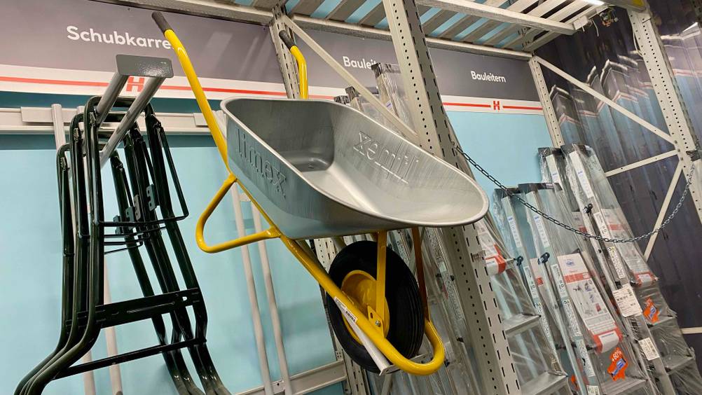Schubkarre getestet: Eine Karre von Limex mit gelbem Unterbau hängt in einem Regal neben andere Produkten.