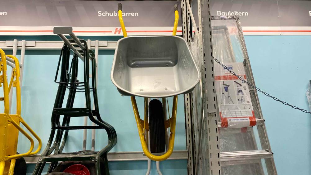 Eine getestete Schubkarre von vorne in einem Verkaufsregal neben anderen Produkten hängend.