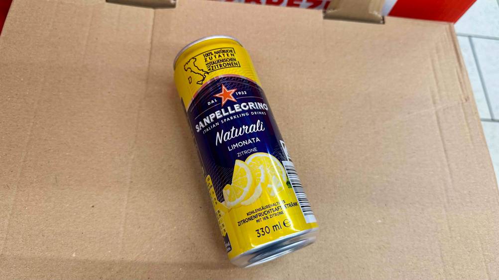 Auf einem Karton liegt eine Dose der Limonade im Test.