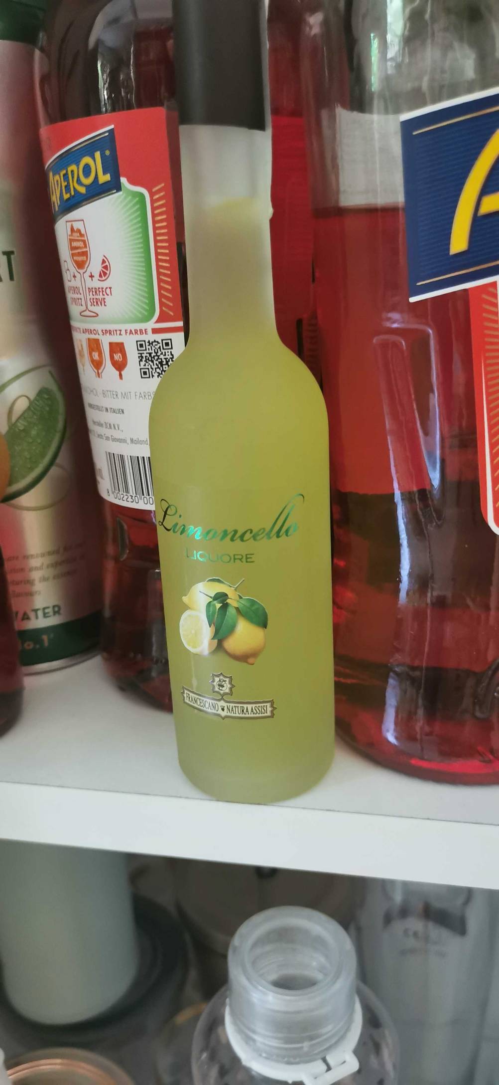 Eine Flasche Limoncello steht zum Testen neben anderen Getränkeflaschen in einem Regal.