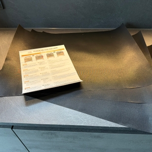 Drei Linda's-Essentials-Dauerbackfolien liegen mit der Anleitung auf einer Küchenarbeitsplatte