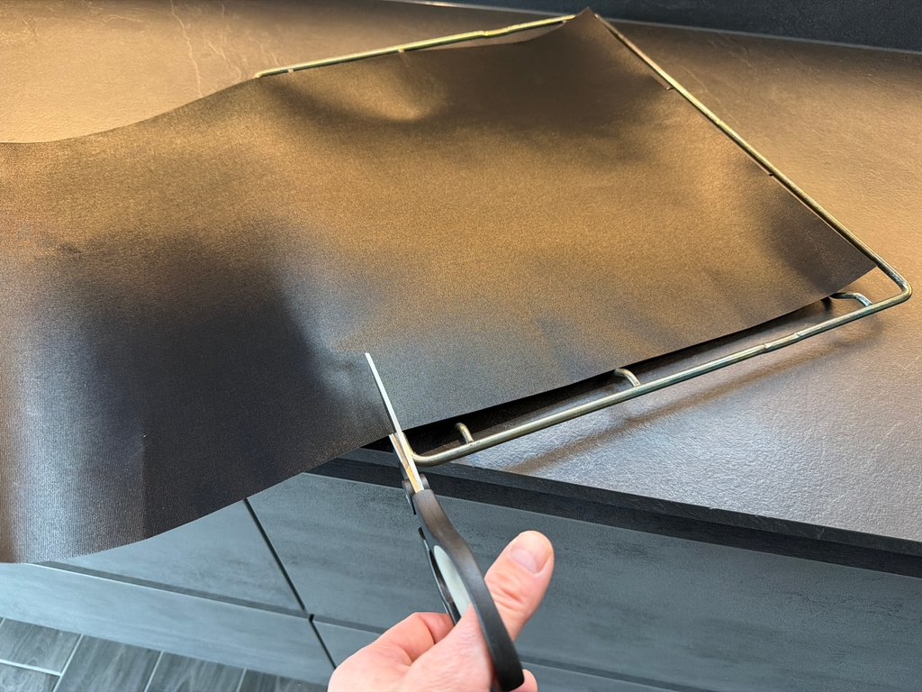 Die Linda's-Essentials-Dauerbackfolie wird mit einer Schere geschnitten.