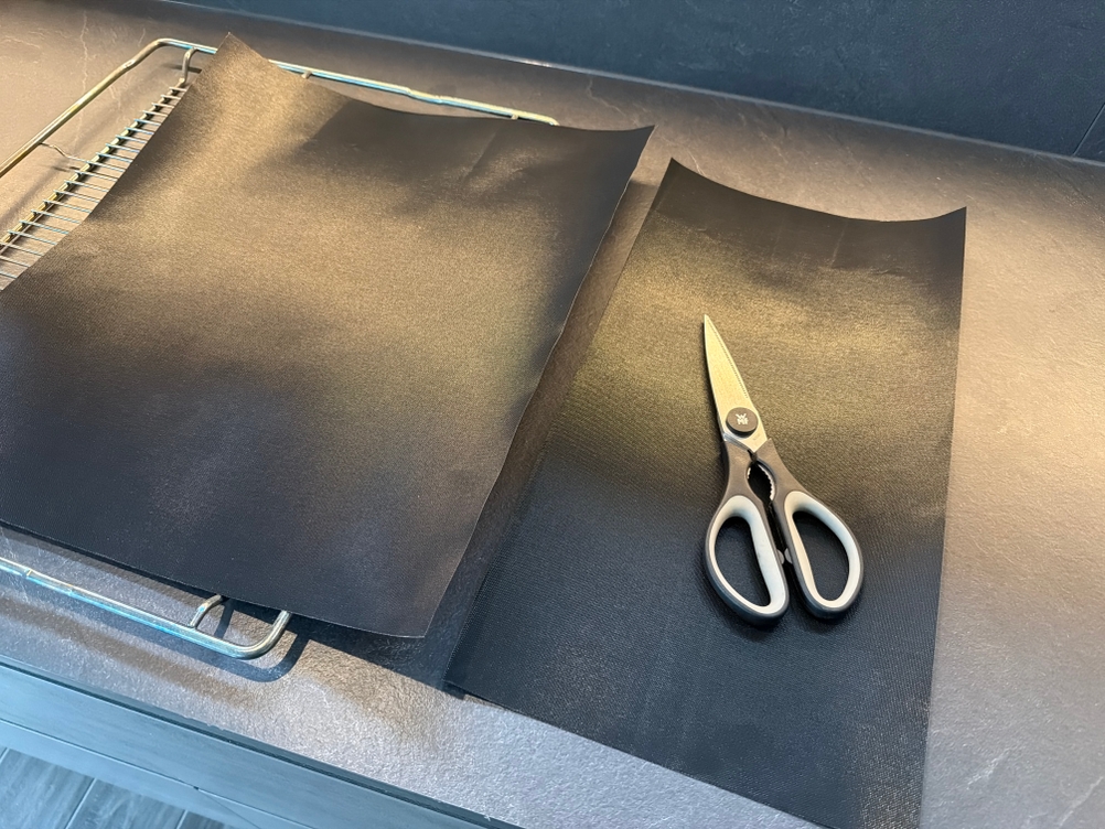 Eine Schere liegt auf der zerschnittenen Linda's-Essentials-Dauerbackfolie