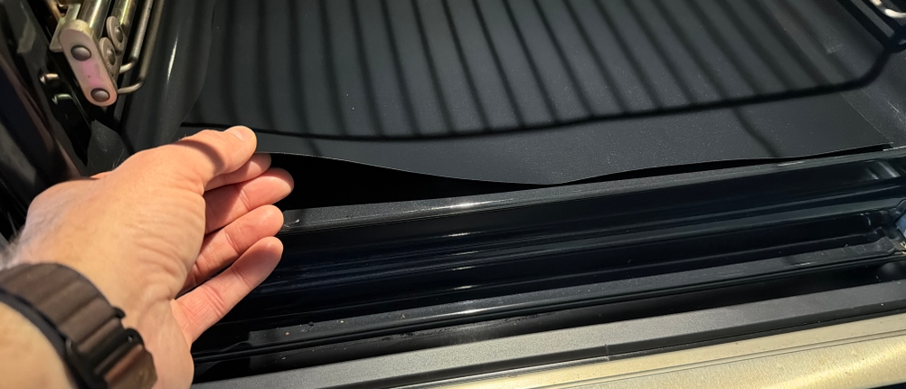 Eine Hand legt die Linda's-Essentials-Dauerbackfolie in einen Ofen