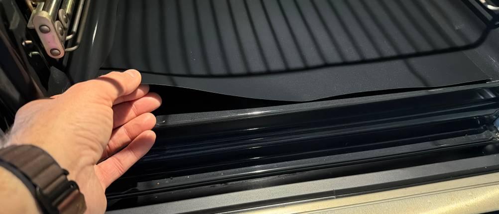 Eine Hand legt die Linda's-Essentials-Dauerbackfolie in einen Ofen