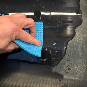 Mit einem Lappen wird die Linda's-Essentials-Dauerbackfolie gereinigt