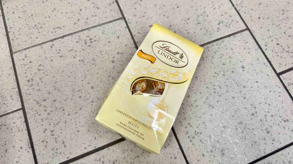 Auf einem Fließenboden liegt eine Packung der getesteten Lindor-Kugeln.