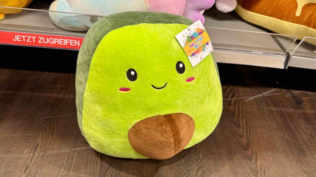 Ein getestetes Squishmallow steht auf einem Holzboden.