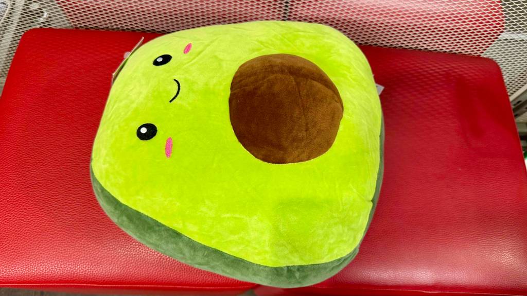 Detailansicht eines auf einem roten Hocker liegenden getesteten Squishmallow.