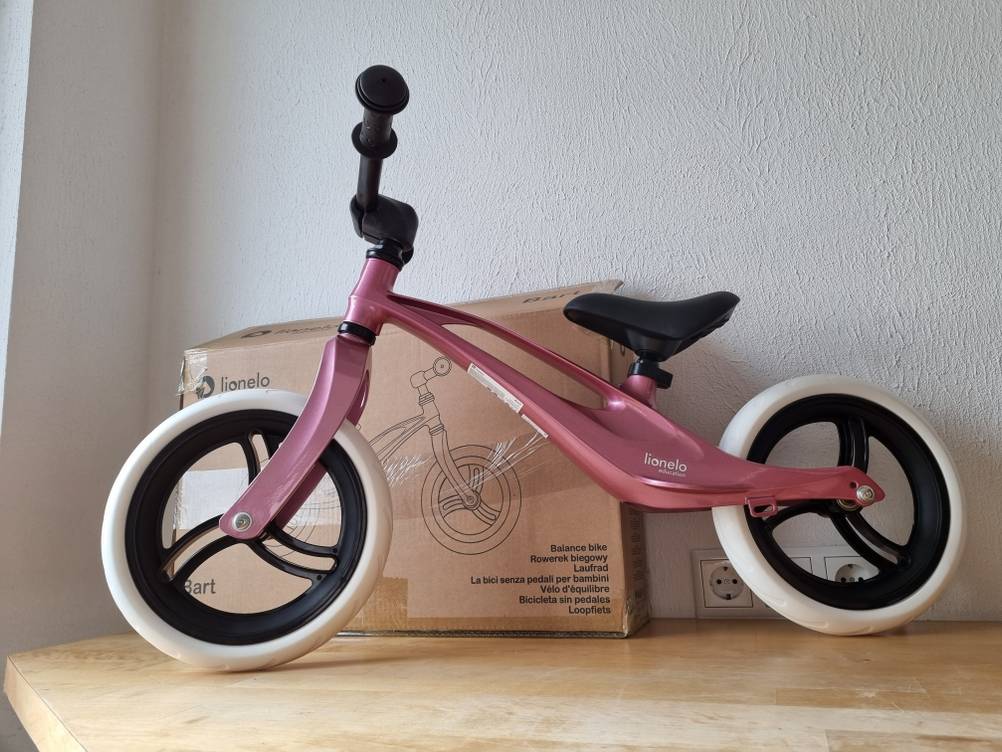 Laufrad-Test: ein rosa Laufrad von Lionelo steht vor einem Lieferkarton