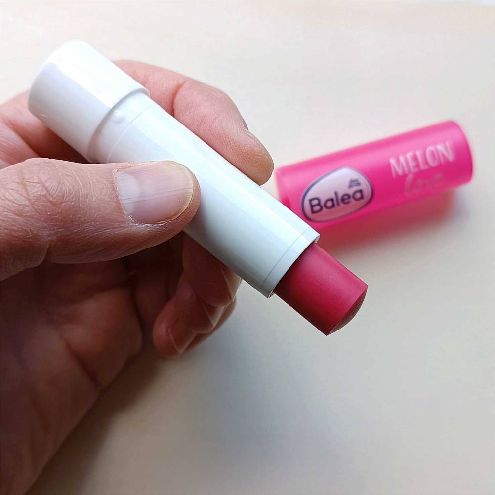 Lippenpflegestift in der Hand