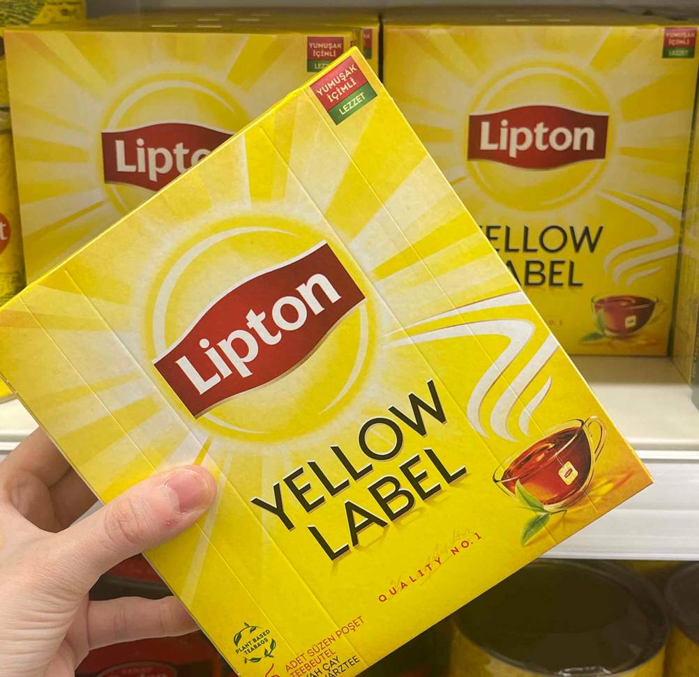 Im Test: Eine Hand hält eine Packung Lipton-Tee vor anderen Packungen.