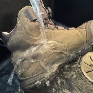 Wasserstrahl, der auf einen imprägnierten Schuh gegossen wird