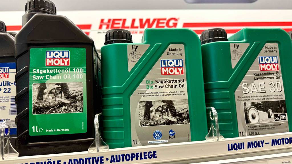 Bio-Sägekettenöl im Test: Mehrere Kanister stehen zwischen anderen Ölsorten in einem Regal.