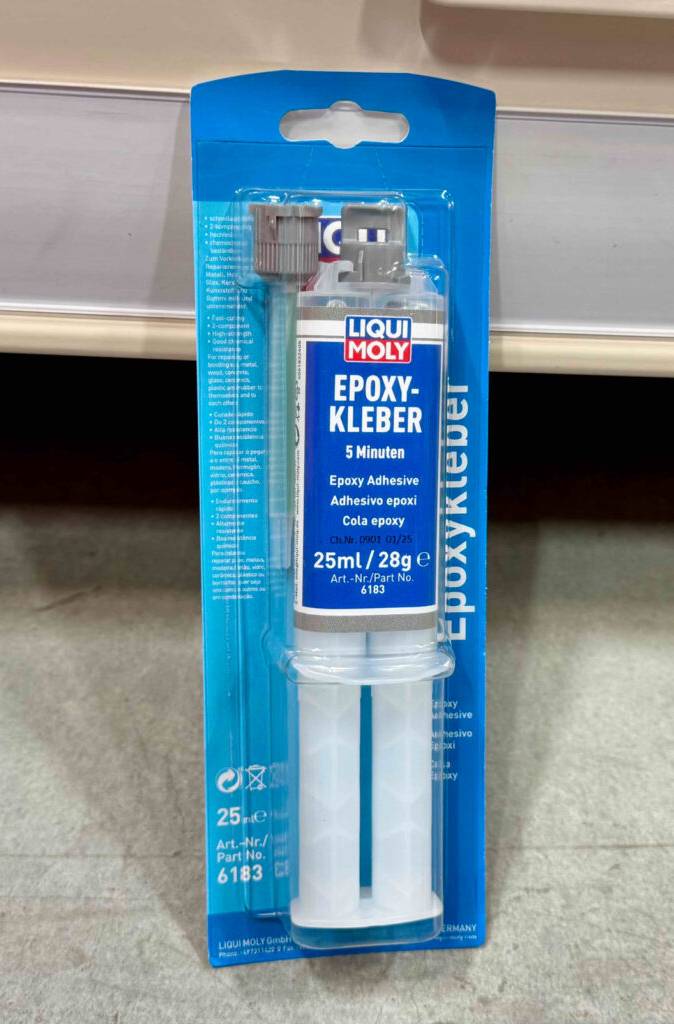 Der getestete Epoxidharz-Kleber von Liqui Moly befindet sich in seiner Verpackung auf dem Boden.