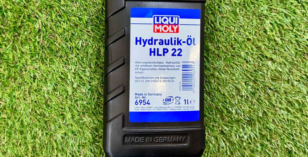 Das getestete Hydraulik-Öl von Liqui Moly liegt in der 1-l-Flasche auf einem grünen Kunstrasen.
