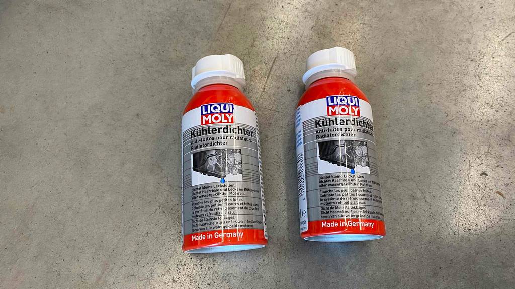 Kühlerdichtmittel getestet: Zwei rote Flaschen Kühlerdichter der Marke Liqui Moly liegen auf einer grauen Oberfläche.