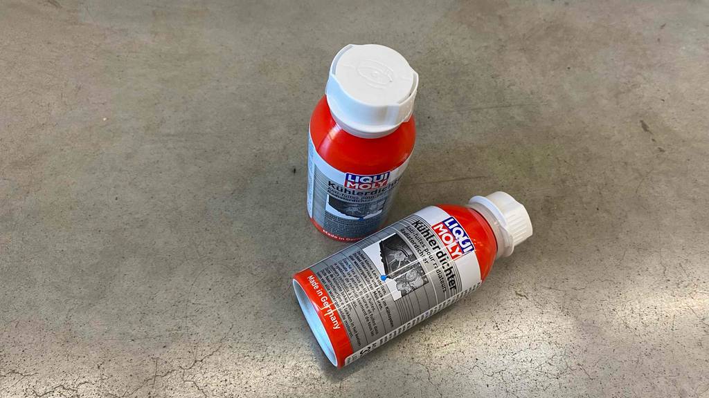 Kühlerdichtmittel-Test: Zwei rote Flaschen Kühlerdichtmittel von Liqui Moly befinden sich auf einem grauen Boden.