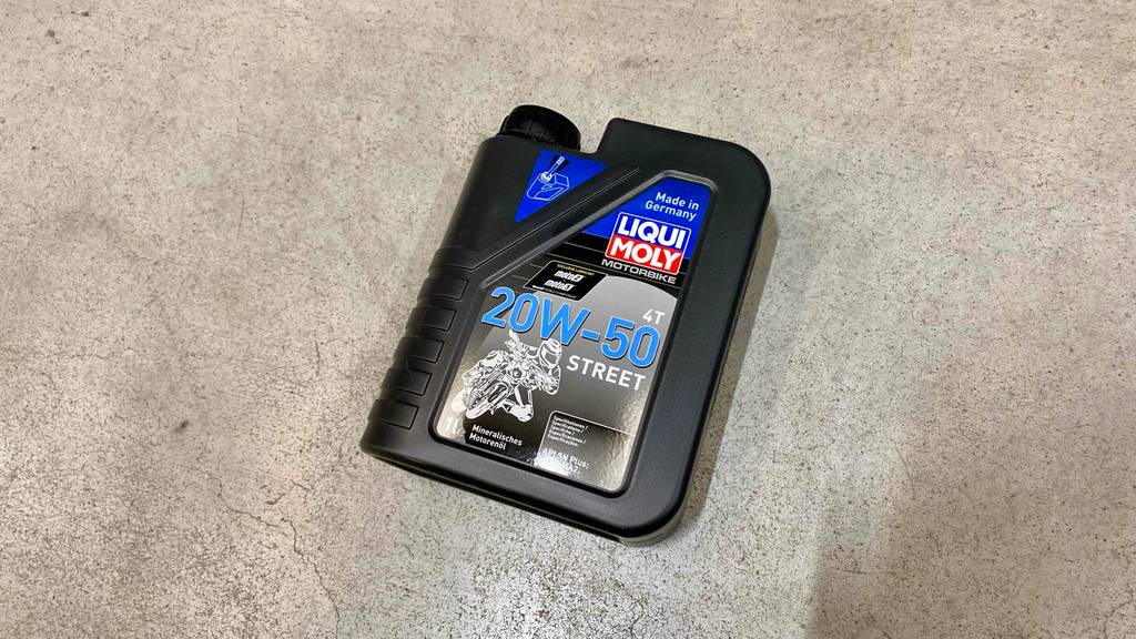 20w50-Motorenöle im Test: ein schwarzes Gebinder der Marke LIQUI MOLY liegt auf einem Zementboden.