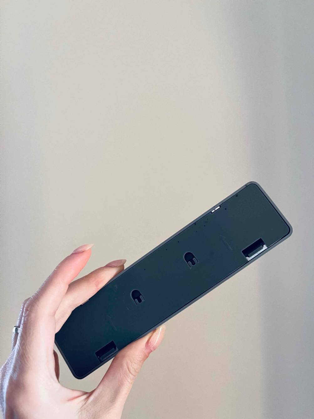 Im Test: Eine Hand hält eine LED-Lightbar mit der Rückseite nach vorn vor einer weißen Wand.