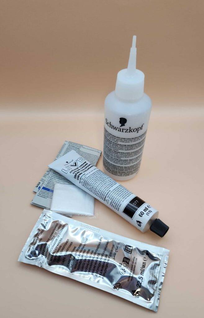 Haarfärbemittel getestet: Mehrere Komponenten von Schwarzkopf befinden sich auf einer beigefarbenen Oberfläche.