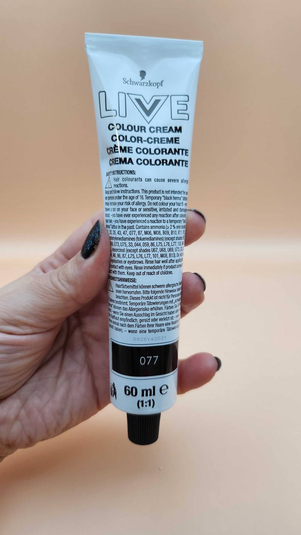 Eine Hand hält eine Tube mit Farbcreme von Schwarzkopf, Teil eines getesteten Haarfärbemittels.