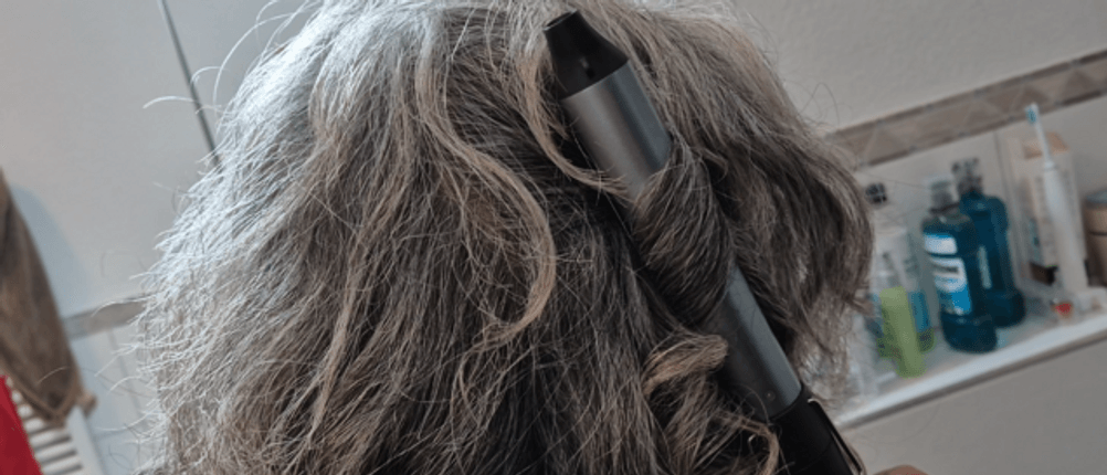 Hinterkopfansicht der Anwendung des Lockenstabs von Remington