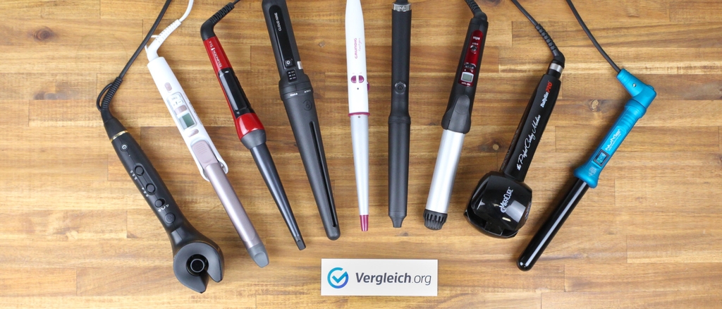 Lockenstab-Test: Verschiedene Lockenstäbe auf einem Holzboden.