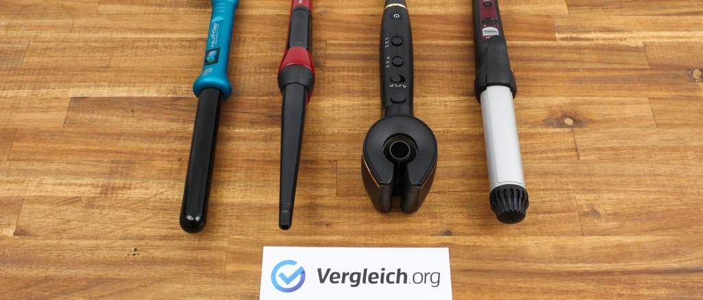 Lockenstab im Test: Verschiedene Lockenstäbe auf Holzboden