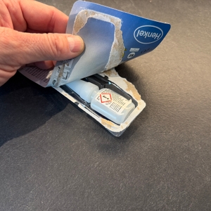 Die Verpackung vom Sekundenkleber Loctite 401 wird geöffnet