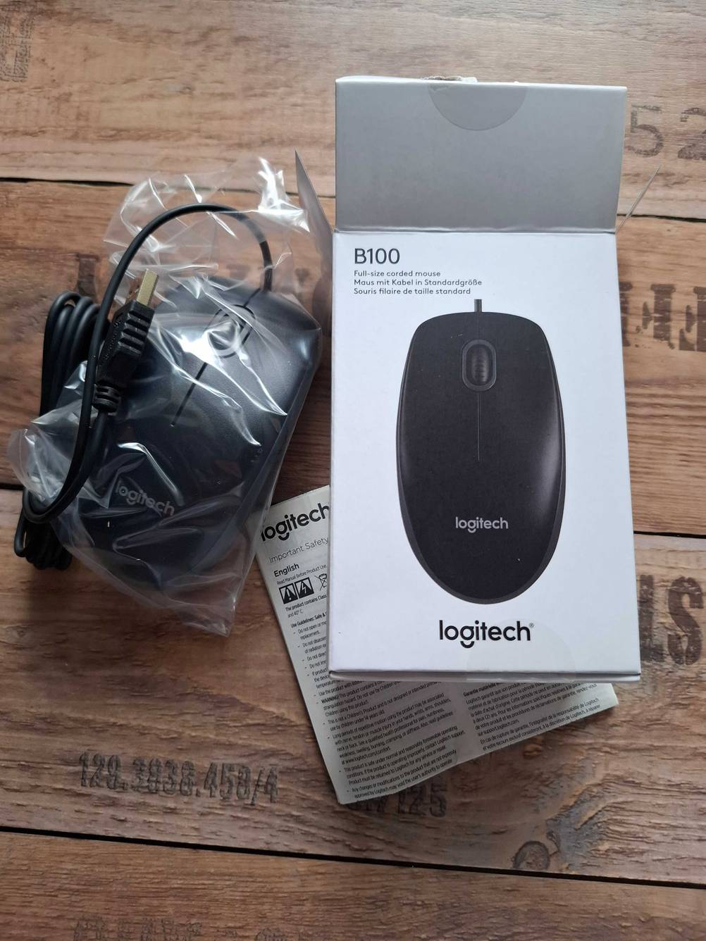 Eine in Plastik verpackte USB-Maus liegt zum testen neben der geöffneten Verpackung.