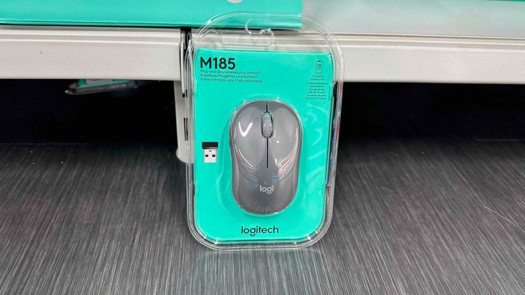 Eine graue Logitech-Funkmaus steht verpackt zum Testen auf einem grauen Boden.