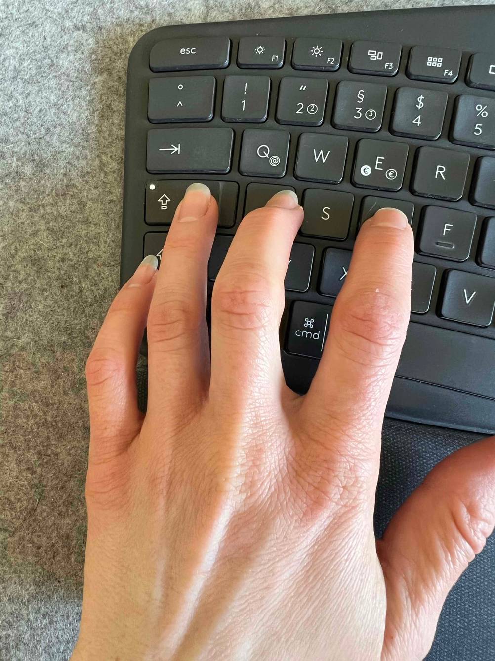 Getestet: Eine Hand tippt auf der linken Seite einer ergonomischen Tastatur.