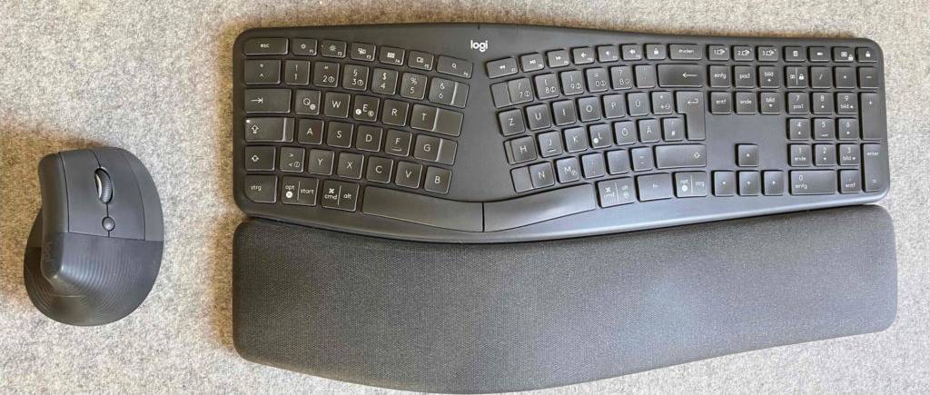 Eine getestete ergonomische Maus liegt links neben einer Tastatur.