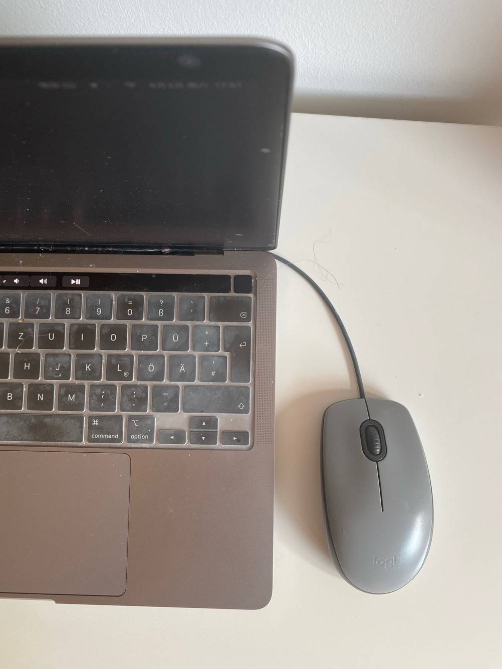 Logitech-Maus getestet: Ein Gerät rechts neben einem Laptop auf einer hellen Fläche.