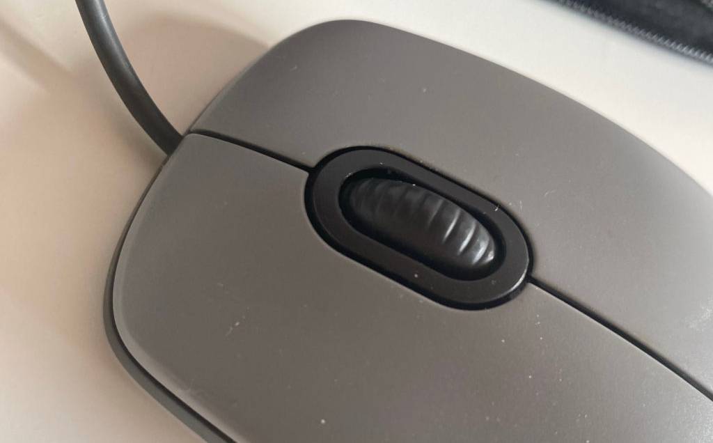 Logitech-Maus-Test: Detailansicht des dunkelgrauen Rädchens auf einer grau-schwarzen Maus auf hellem Untergrund.